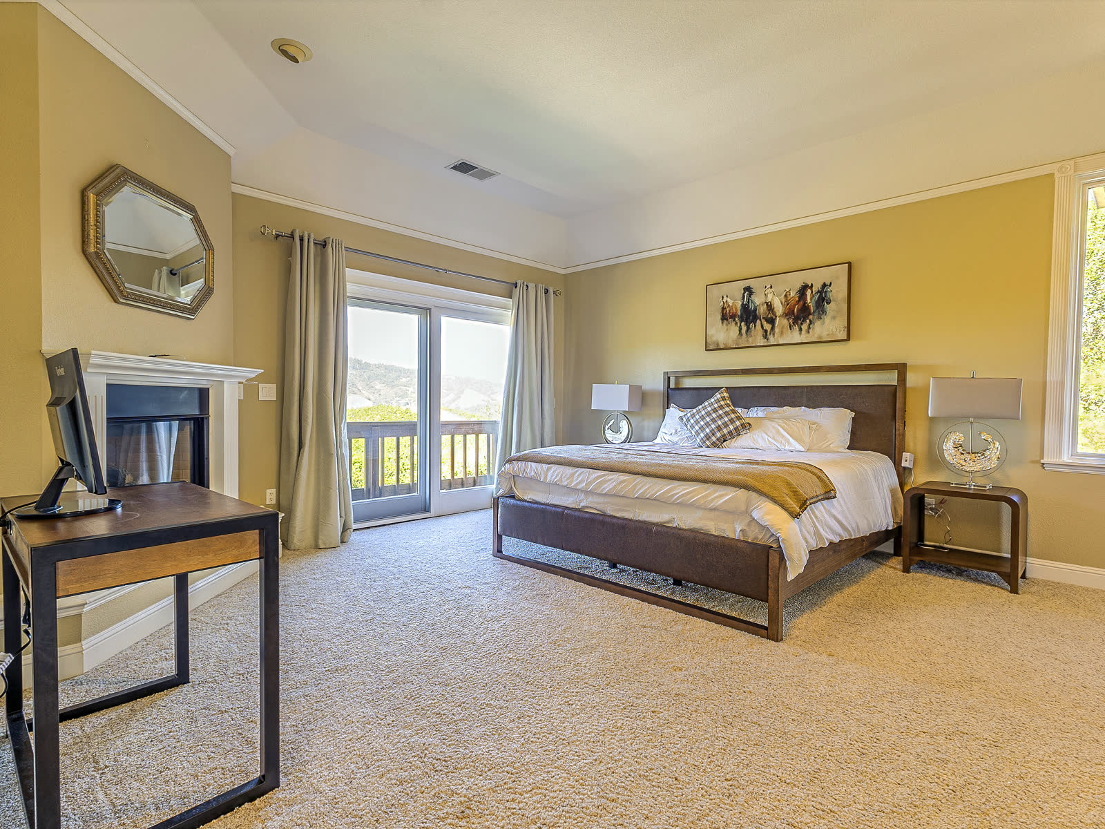 The primary suite, with the fireplace and the balcony door